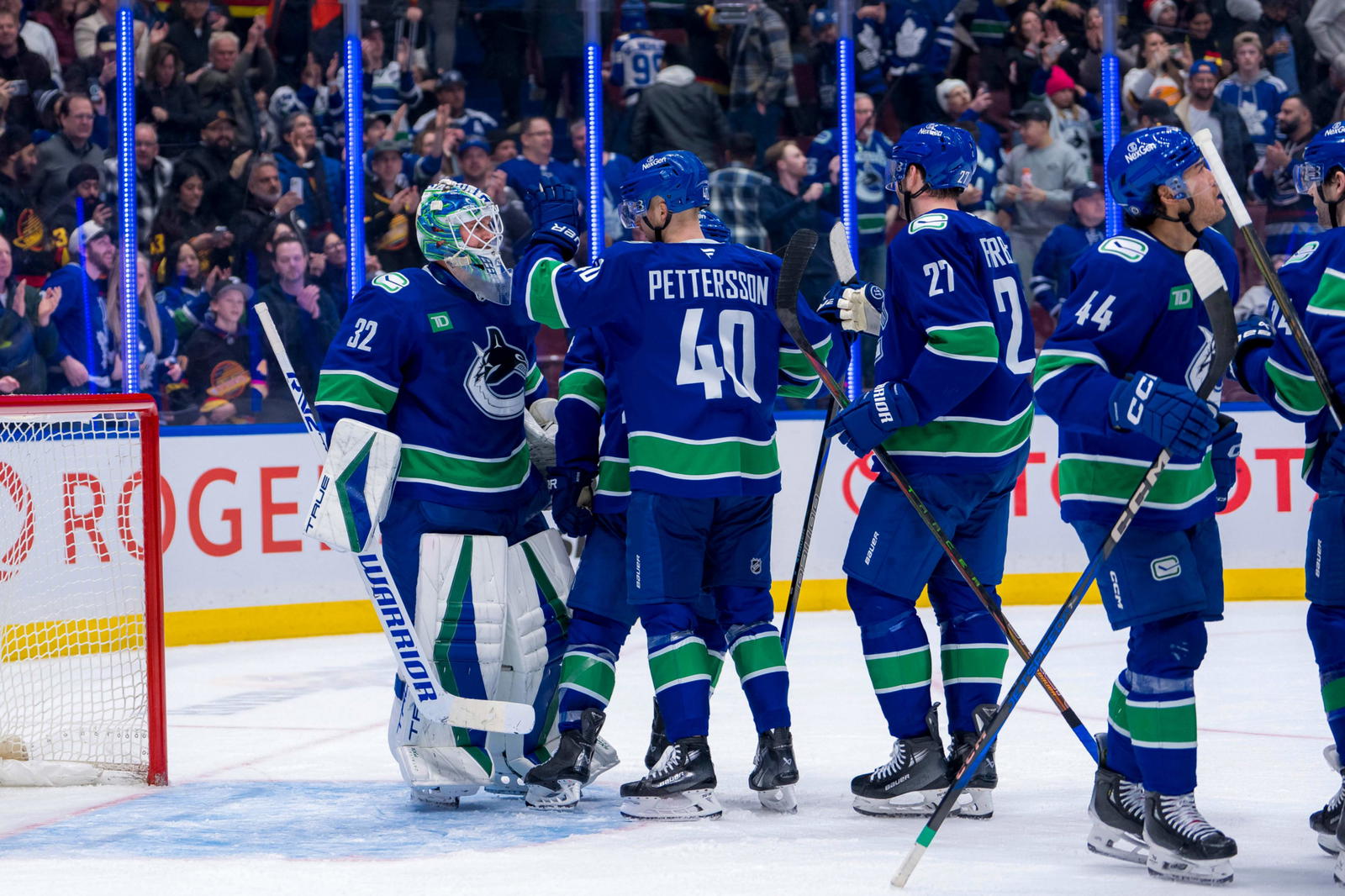 Feb 8, 2025; Vancouver, British Columbia, CAN; Vancouver Canucks goalie Kevin Lankinen (32) and forward Elias Pettersson (40) and forward Elias Pettersson (40) and defenseman Derek Forbort (27) and forward Kiefer Sherwood (44) celebrate the victory against the Toronto Maple Leafs at Rogers Arena. Mandatory Credit: Bob Frid-Imagn Images