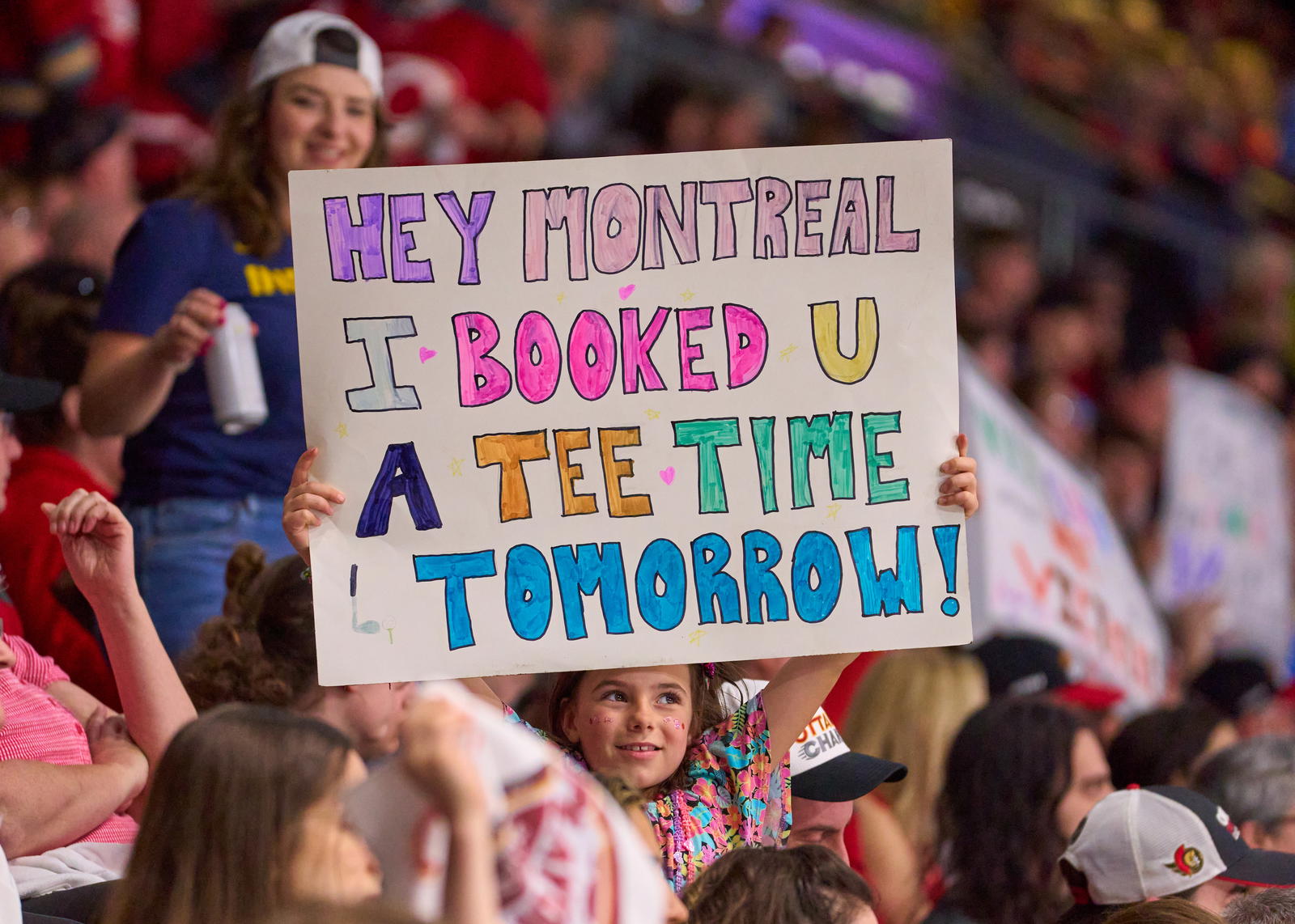A youth holds up a sign telling the Montreal Victoire that they'll be headed for the golf course soon at TD Place Arena in Ottawa -&nbsp;Photo @ Ellen Bond