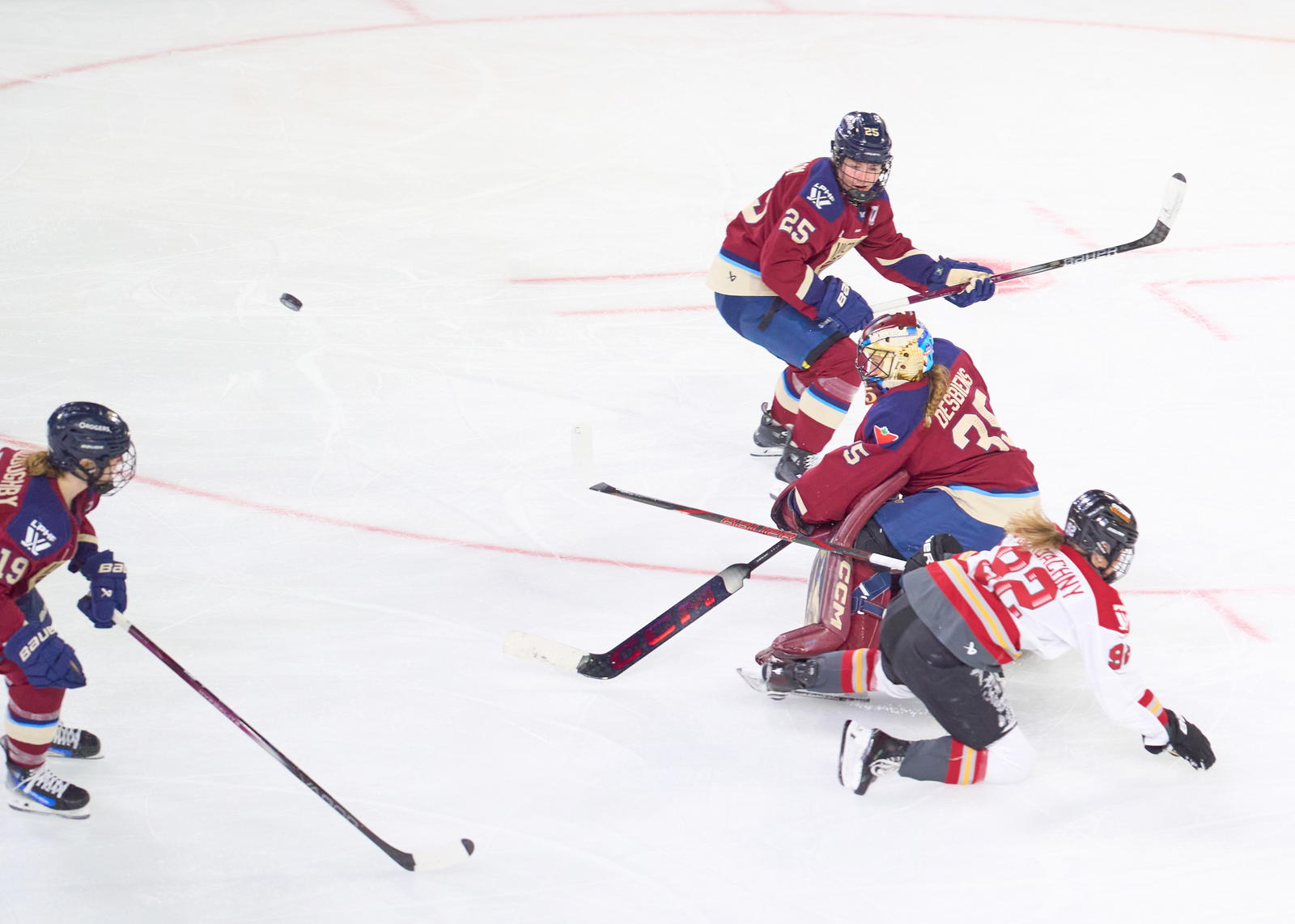 Ann-Renee Desbiens, Montreal's netminder, wins a race to the puck in overtime against Ottawa's Danielle Serdachny - Photo @ Ellen Bond