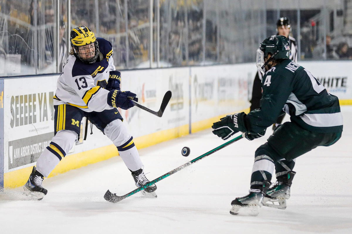 Michigan center TJ Hughes makes a pass against Michigan State defenseman Nash Nienhuis during the third period at Yost Ice Arena in Ann Arbor on Friday, Feb. 9, 2024.