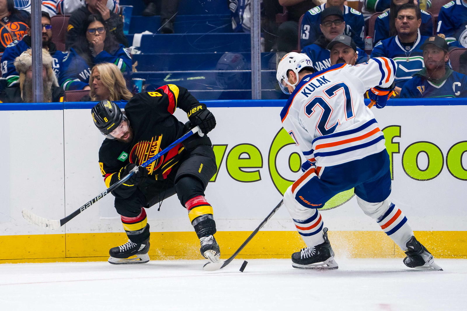 Nov 9, 2024; Vancouver, British Columbia, CAN; Edmonton Oilers defenseman Brett Kulak (27) stick checks Vancouver Canucks forward Conor Garland (8) during the second period at Rogers Arena. Mandatory Credit: Bob Frid-Imagn Images