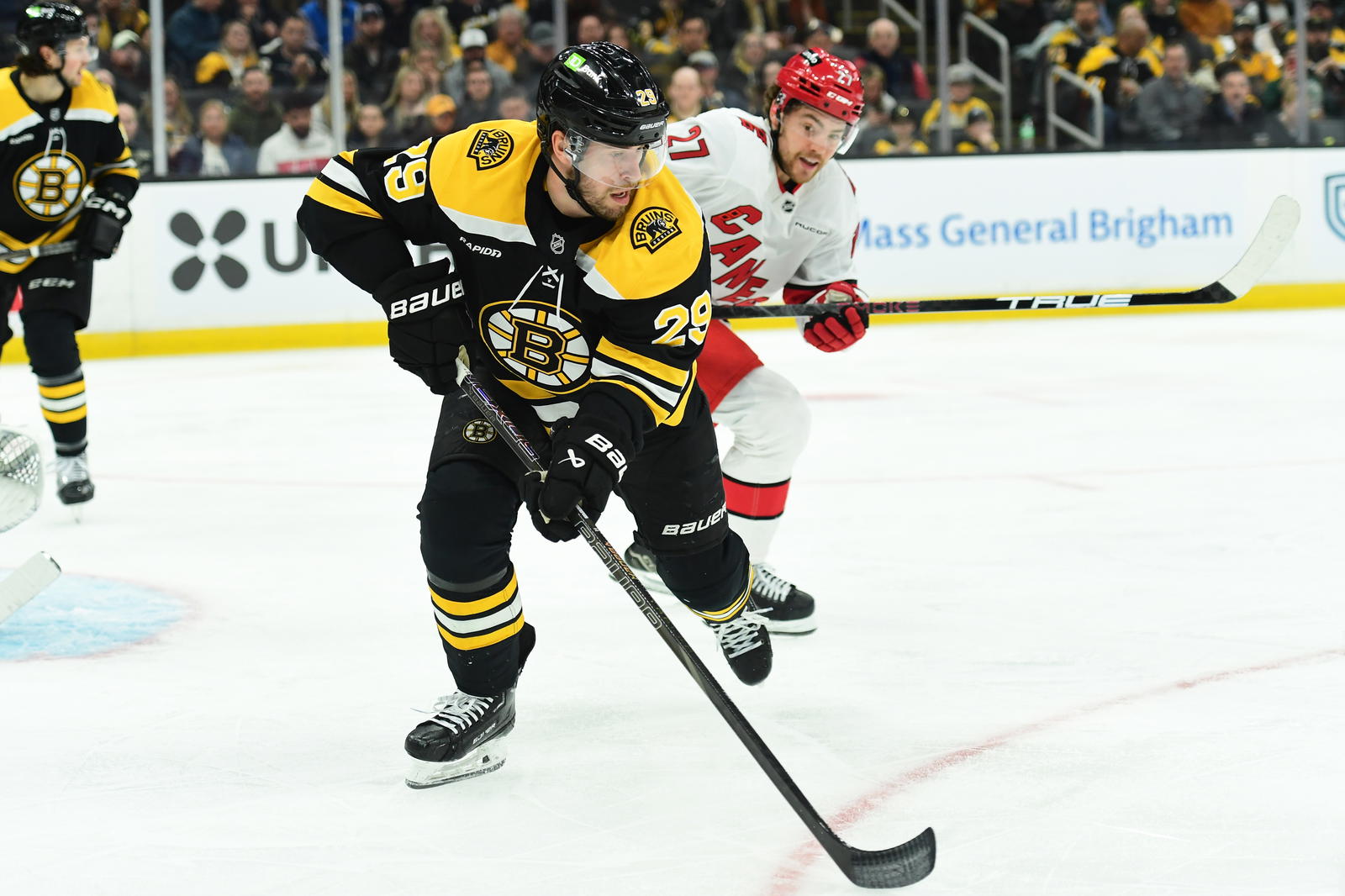 Apr 5, 2025; Boston, Massachusetts, USA; Boston Bruins defenseman Parker Wotherspoon (29) controls the puck away from Carolina Hurricanes center Tyson Jost (27) during the second period at TD Garden. Mandatory Credit: Bob DeChiara-Imagn Images