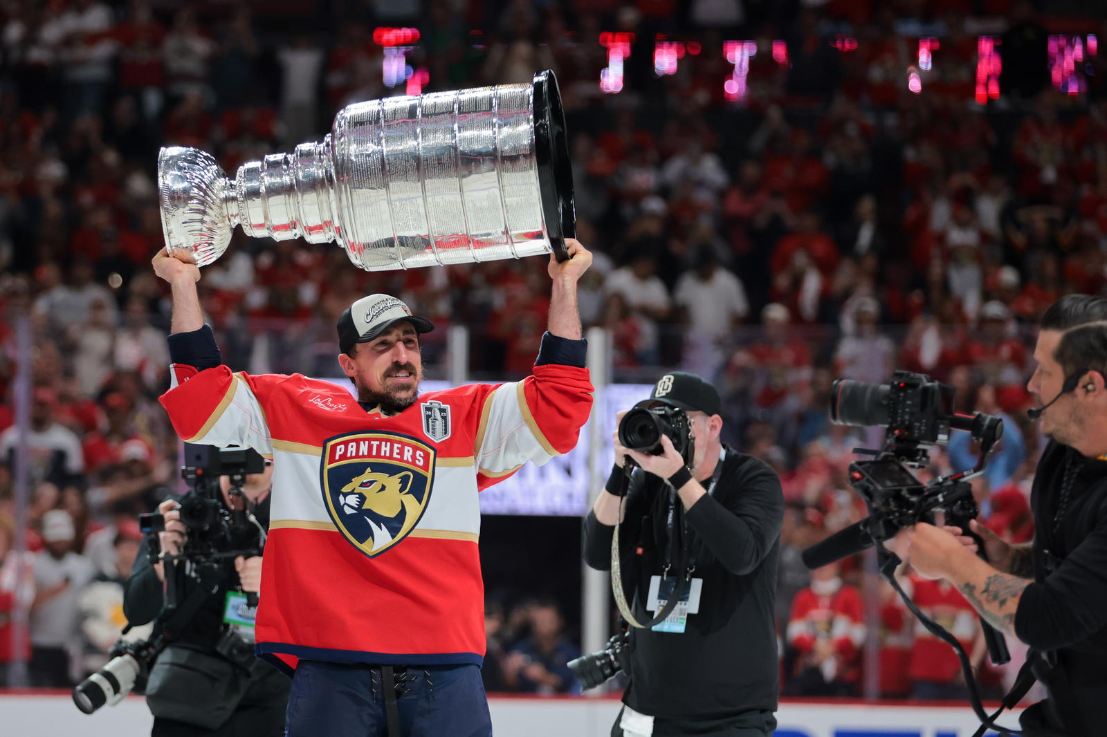 Jun 17, 2025; Sunrise, Florida, USA; Florida Panthers center Brad Marchand (63) hoists the Stanley Cup after winning game six of the 2025 Stanley Cup Final against the Edmonton Oilers at Amerant Bank Arena. Mandatory Credit: Sam Navarro-Imagn Images.