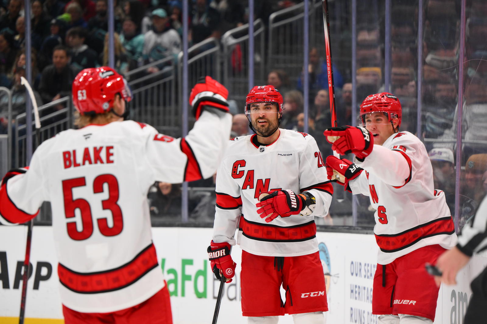 Oct 26, 2024; Seattle, Washington, USA; Carolina Hurricanes right wing Jackson Blake (53) and left wing William Carrier (28) and center Jack Drury (18) celebrate after a goal scored by Drury during the second period against the Seattle Kraken at Climate Pledge Arena. (Steven Bisig-Imagn Images)