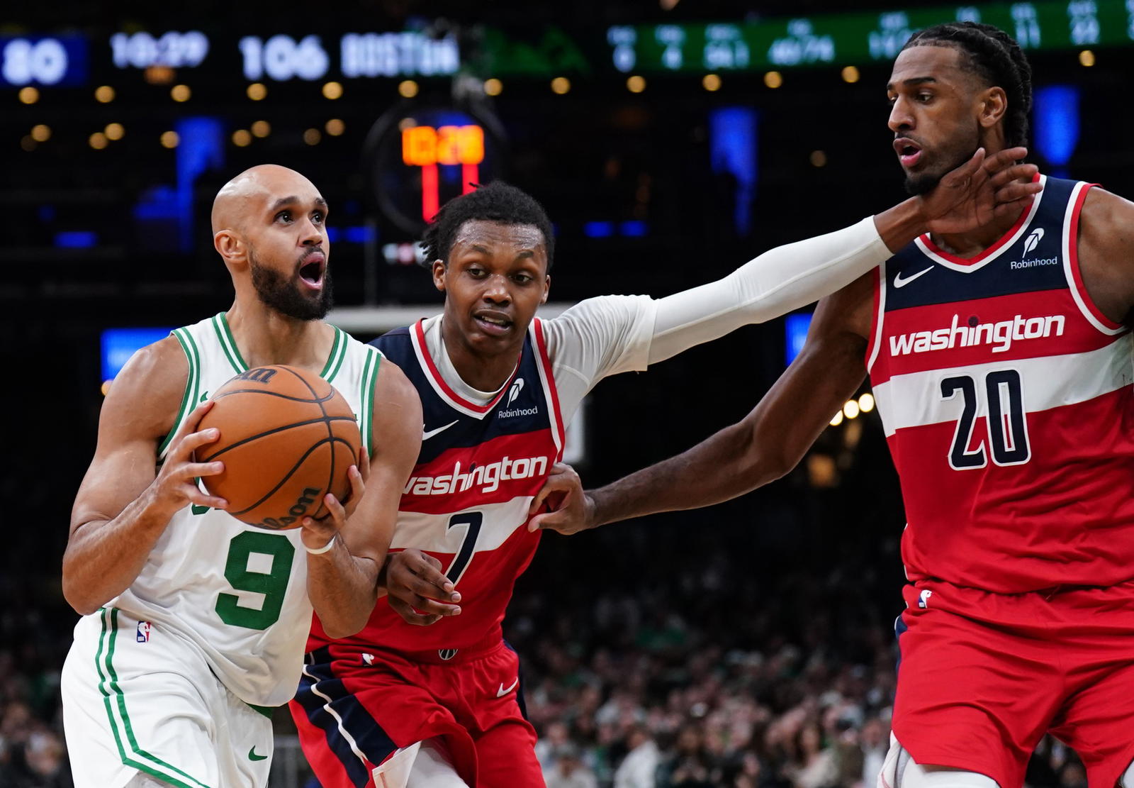 Nov 5, 2025; Boston, Massachusetts, USA; Boston Celtics guard Derrick White (9) drives the ball against Washington Wizards guard Bub Carrington (7) and center Alex Sarr (20) in the second half at TD Garden. (David Butler II/Imagn Images)