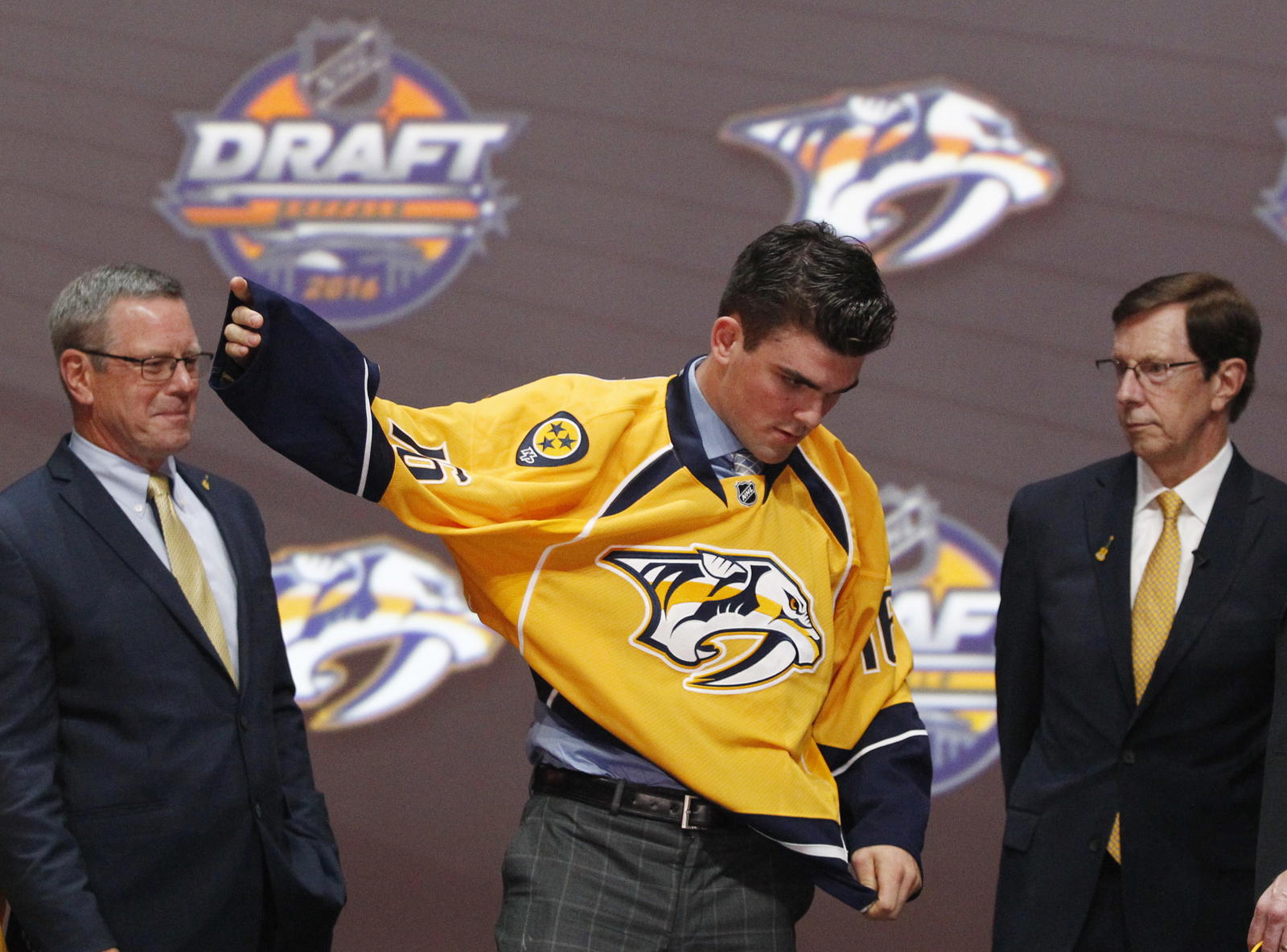Jun 24, 2016; Buffalo, NY, USA; Dante Fabbro puts on a team jersey after being selected as the number seventeen overall draft pick by the Nashville Predators in the first round of the 2016 NHL Draft at the First Niagra Center. Mandatory Credit: Timothy T. Ludwig-Imagn Images