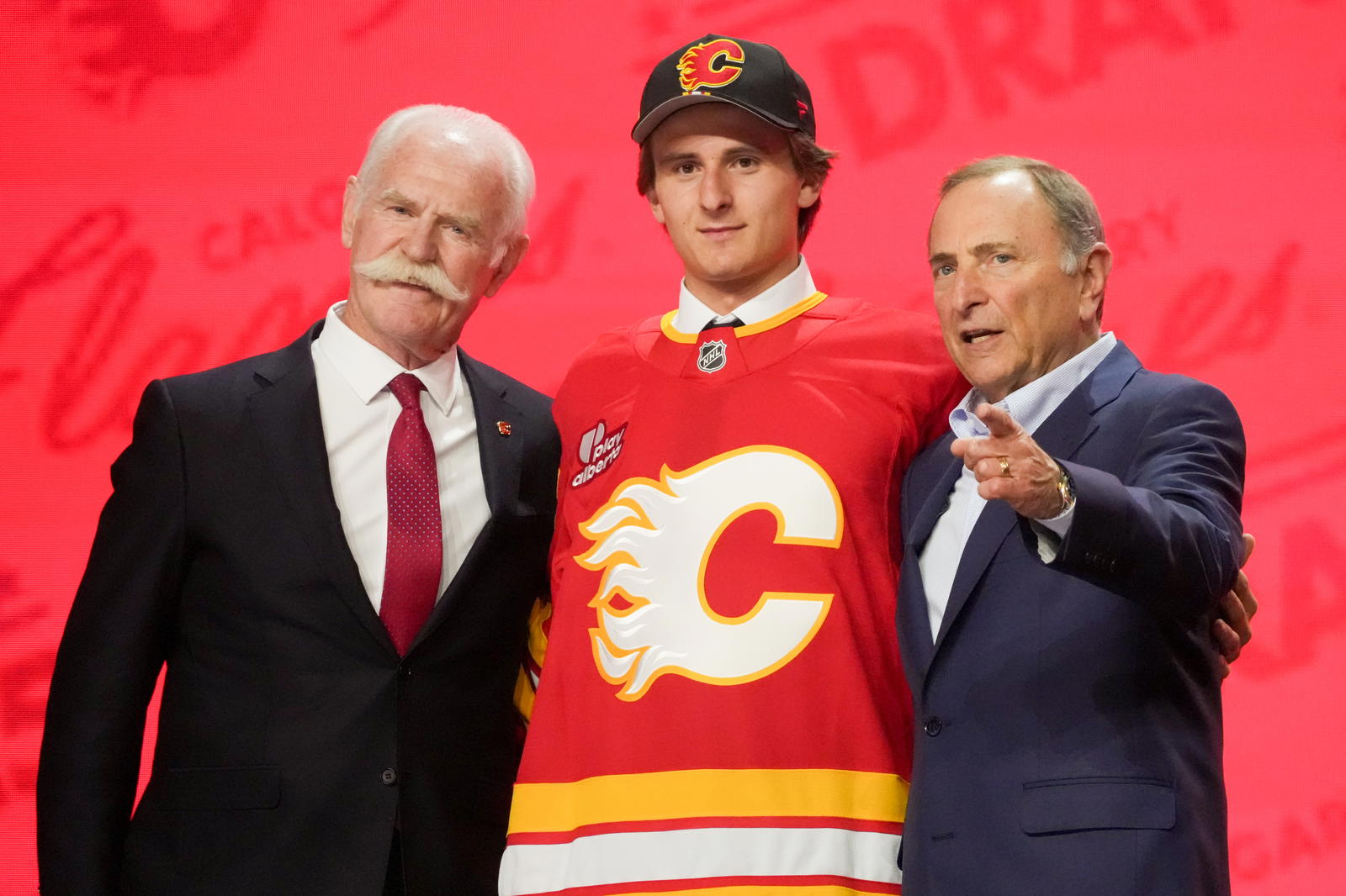 Cole Reschny stands with NHL commissioner Gary Bettman and Flames legend Lanny McDonald as he is selected 18th overall to the Calgary Flames in the first round of the 2025 NHL Draft at the Peacock Theater in Los Angeles (Photo: Kirby Lee-Imagn Images)