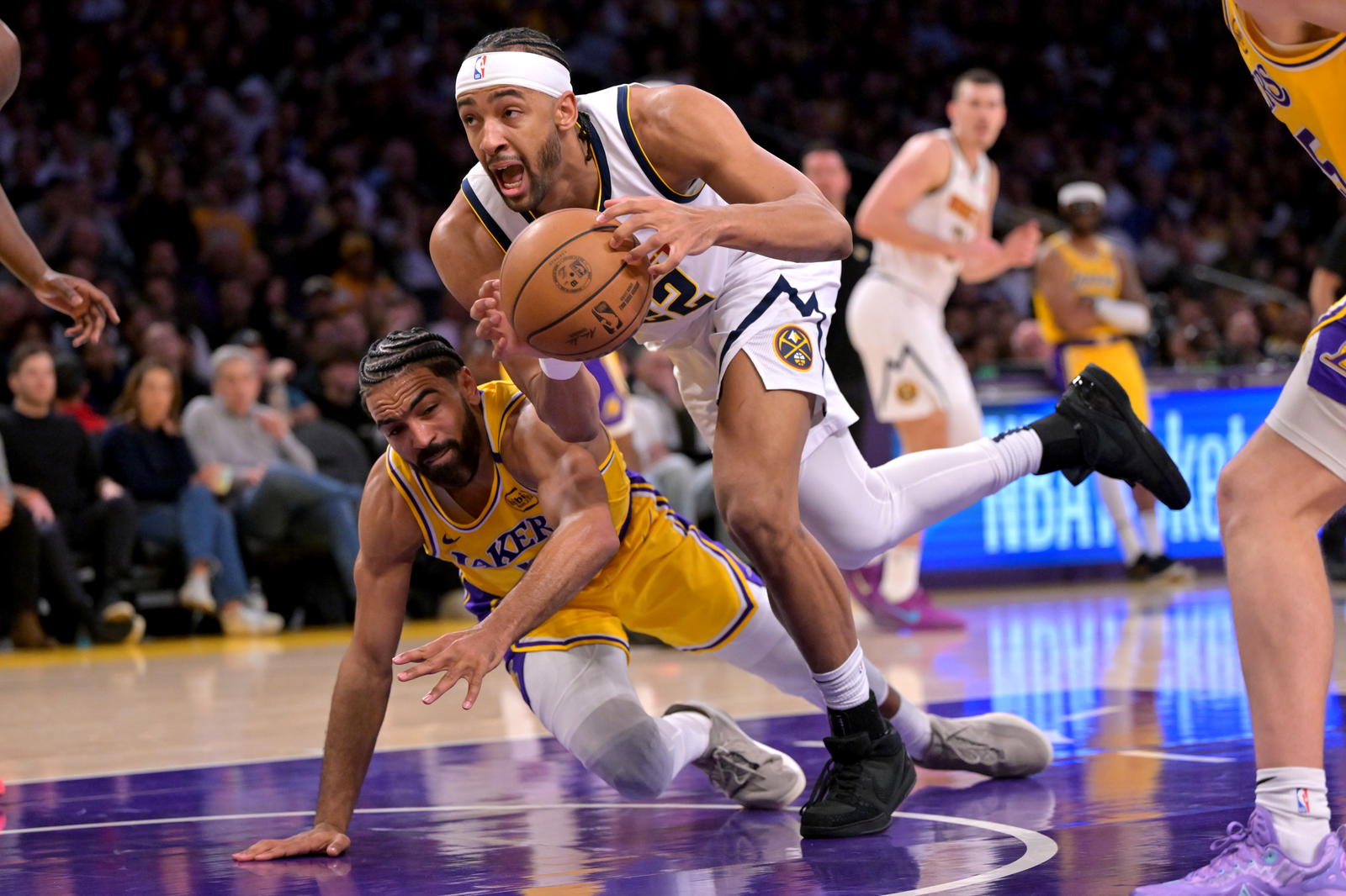 Los Angeles Lakers guard Gabe Vincent (7) and Denver Nuggets forward Zeke Nnaji (22) reach for a loose ball in the second half at Crypto.com Arena.&nbsp;Jayne Kamin-Oncea-Imagn Images