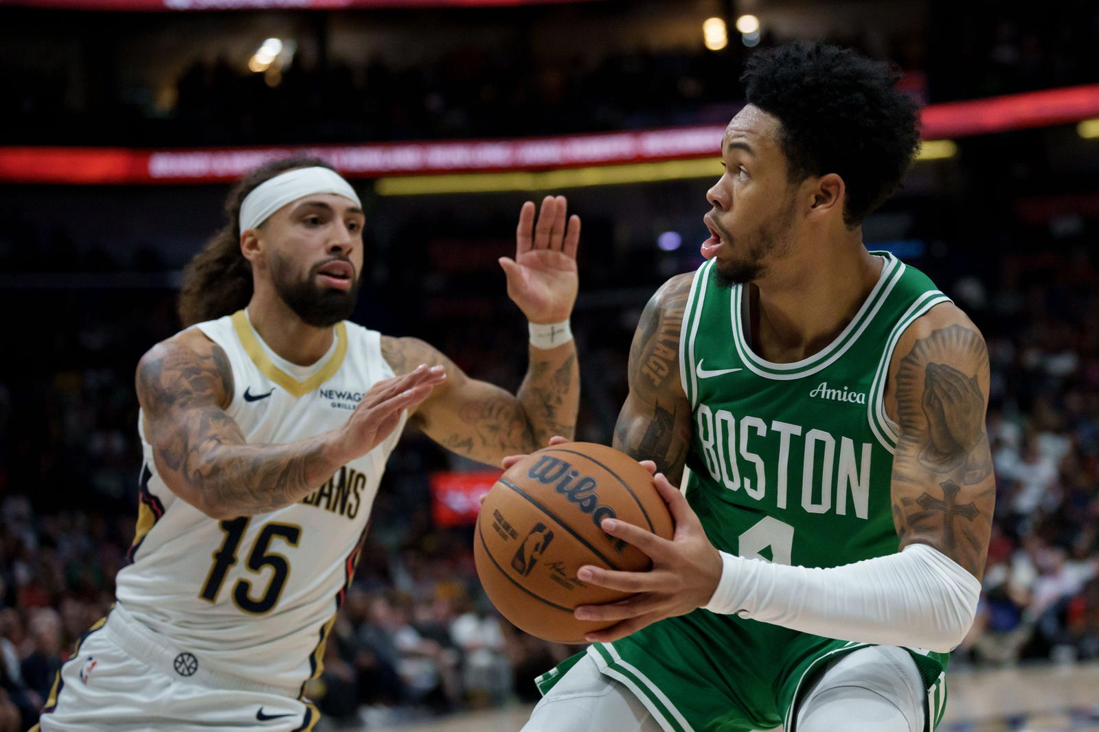 Oct 27, 2025; New Orleans, Louisiana, USA; Boston Celtics guard Anfernee Simons (4) shoots against New Orleans Pelicans guard Jose Alvarado (15) during the first half at Smoothie King Center. (Matthew Hinton/Imagn Images)
