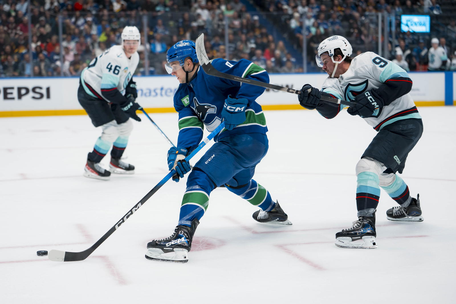 Sep 26, 2025; Vancouver, British Columbia, CAN; Seattle Kraken forward Chandler Stephenson (9) stick checks Vancouver Canucks forward Danila Klimovich (9) in the third period at Rogers Arena. Mandatory Credit: Bob Frid-Imagn Images