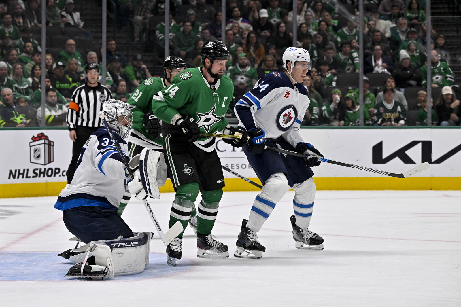 Dec 1, 2024; Dallas, Texas, USA; Winnipeg Jets goaltender Connor Hellebuyck (37) and defenseman Logan Stanley (64) and Dallas Stars left wing Jamie Benn (14) in action during the game between the Dallas Stars and the Winnipeg Jets at American Airlines Center. Mandatory Credit: Jerome Miron-Imagn Images