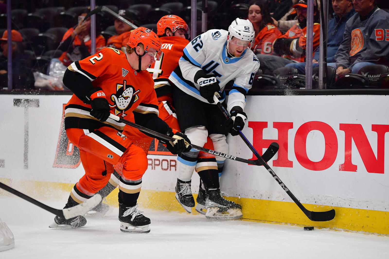 Sep 22, 2025; Anaheim, California, USA; Anaheim Ducks defenseman Jackson LaCombe (2) and left wing Ross Johnston (44) play for the puck against Utah Mammoth left wing Ben McCartney (62) during the third period at Honda Center. Mandatory Credit: Gary A. Vasquez-Imagn Images