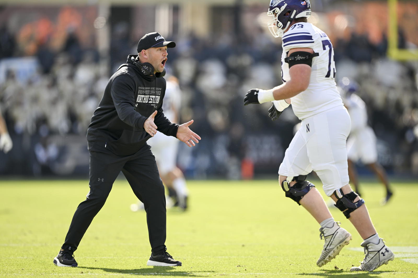 Nov 2, 2024; West Lafayette, Indiana, USA; Northwestern Wildcats head coach David Braun reacts to a touchdown in front of Northwestern Wildcats offensive lineman Deuce McGuire (73) during the second quarter at Ross-Ade Stadium. Mandatory Credit: Marc Lebryk-Imagn Images