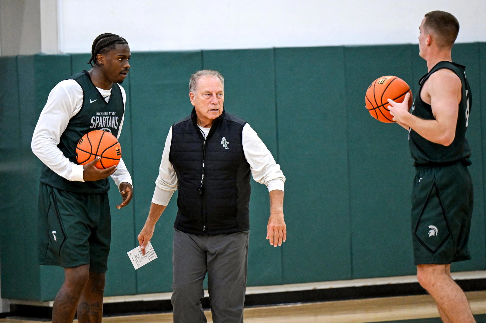 Michigan State's coach Tom Izzo, left, talks with Coen Carr, left, and Denham Wojcik during the first day of basketball practice on Monday, Sept. 22, 2025, at the Breslin Center in East Lansing.