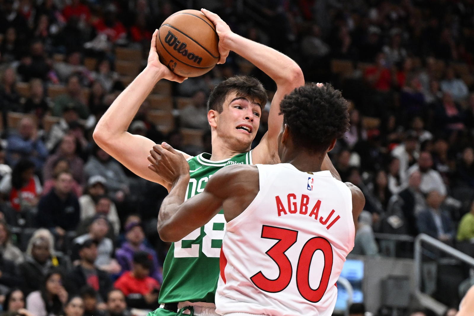 Oct 10, 2025; Toronto, Ontario, CAN; Boston Celtics forward Hugo Gonzalez (28) looks to make a pass against Toronto Raptors guard Ochai Agbaji (30) in the first half at Scotiabank Arena. (Dan Hamilton/Imagn Images)