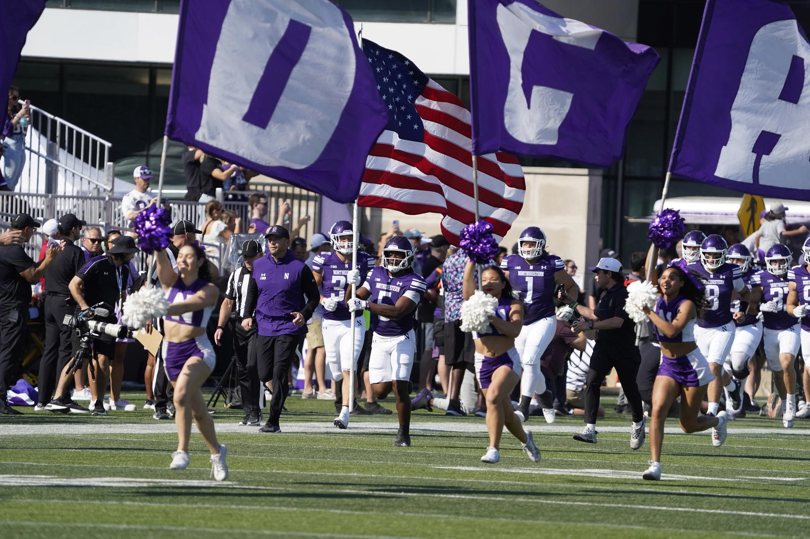 Oct 4, 2025; Evanston, Illinois, USA; The Northwestern Wildcats cheerleaders lead the team on the field before a game against the ULM Warhawks at Northwestern Medicine Field at Martin Stadium. Mandatory Credit: David Banks-Imagn Images