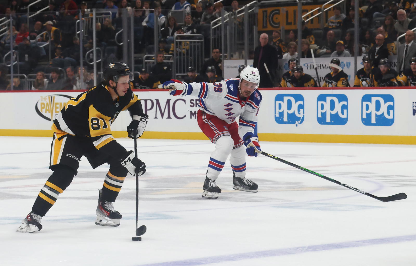 Oct 11, 2025; Pittsburgh, Pennsylvania, USA; Pittsburgh Penguins center Ben Kindel (81) skates with the puck as New York Rangers center Sam Carrick (39) chases during the third period at PPG Paints Arena. Mandatory Credit: Charles LeClaire-Imagn Images