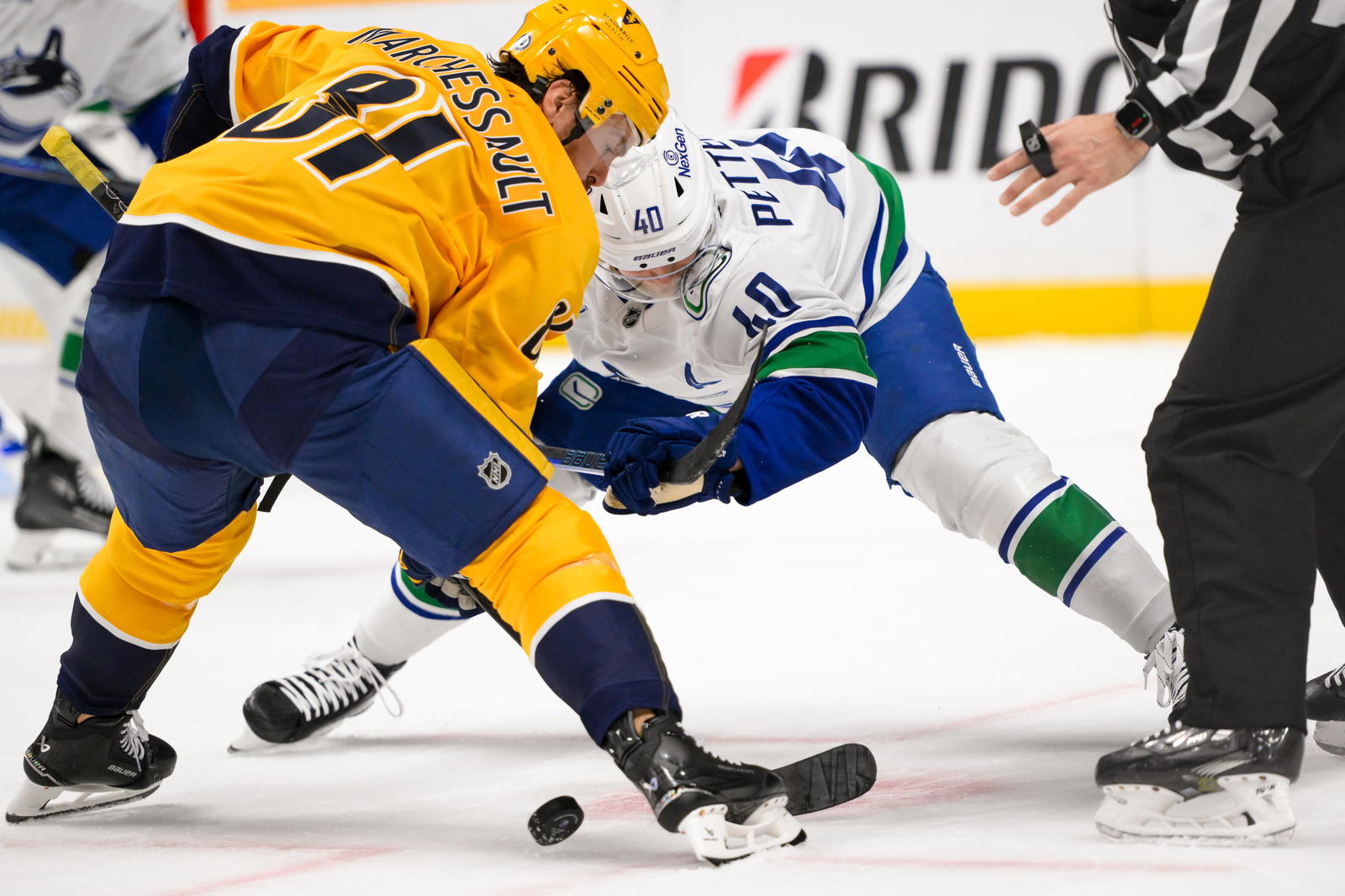 Jan 29, 2025; Nashville, Tennessee, USA; Nashville Predators center Jonathan Marchessault (81) and Vancouver Canucks center Elias Pettersson (40) face off during the first period at Bridgestone Arena. Mandatory Credit: Steve Roberts-Imagn Images