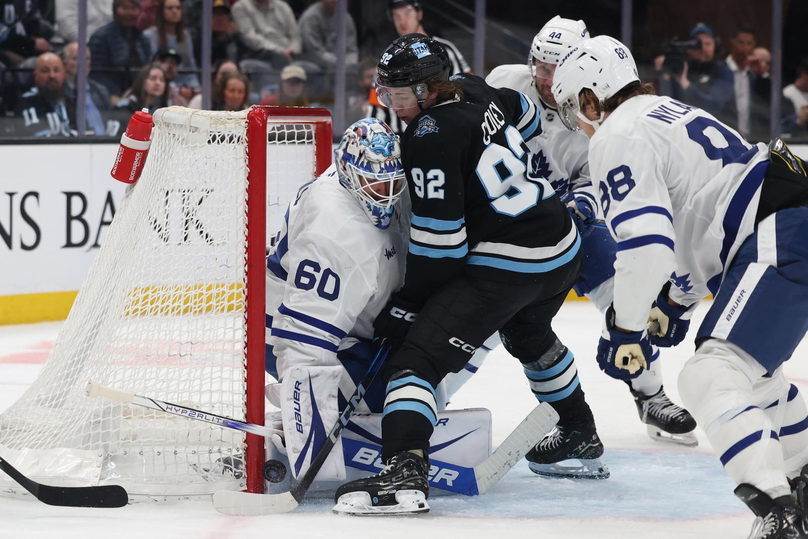 Mar 10, 2025; Salt Lake City, Utah, USA; Utah Hockey Club center Logan Cooley (92) attempts a shot on Toronto Maple Leafs goaltender Joseph Woll (60) during the third period at Delta Center. Mandatory Credit: Rob Gray-Imagn Images