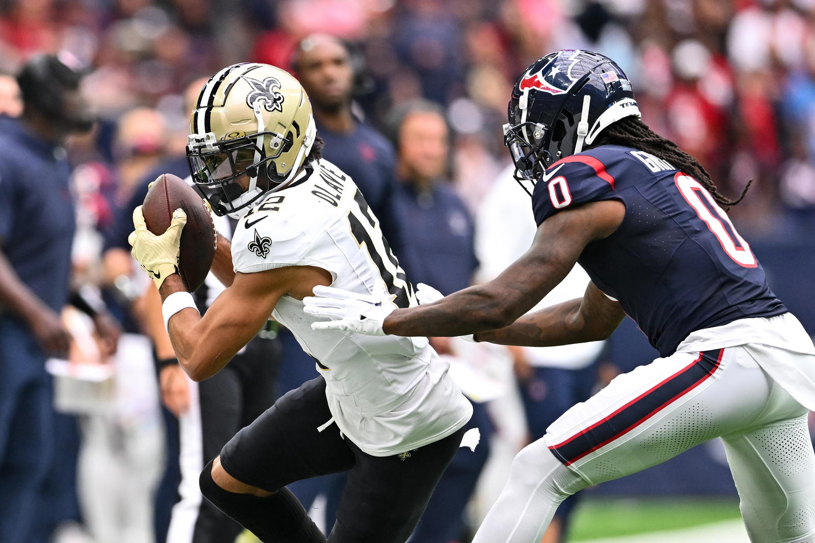 New Orleans Saints wide receiver Chris Olave (12) runs the ball as Houston Texans cornerback Shaquill Griffin (0) defends during the second quarter at NRG Stadium. Maria Lysaker-Imagn Images