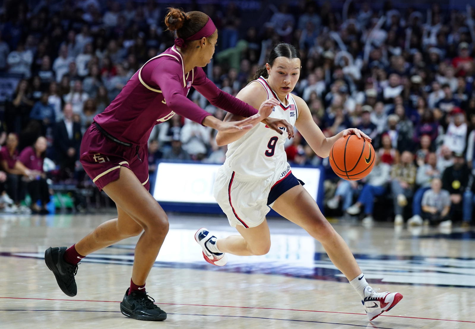 UConn guard Kayleigh Heckel (9) drives the ball against Florida State Seminoles guard Tatum Greene (13) in the second half on Sunday at Harry A. Gampel Pavilion. Credit: David Butler II-Imagn Images