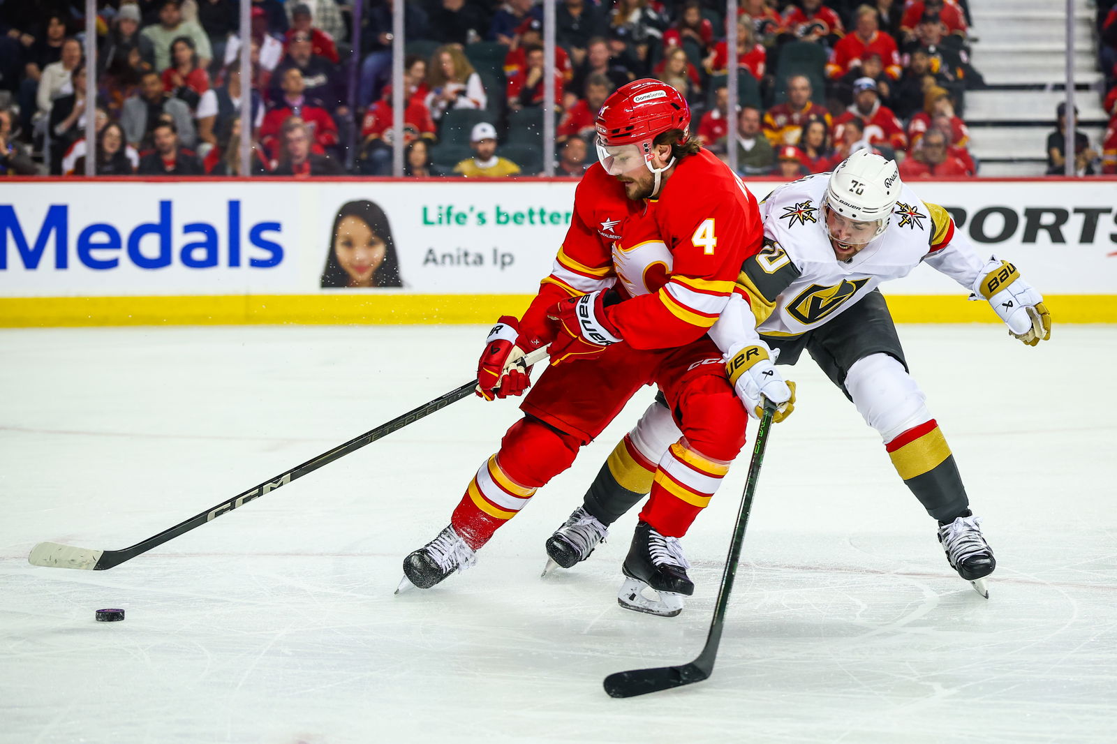 Calgary Flames defenseman Rasmus Andersson (4) and Vegas Golden Knights left wing Tanner Pearson (70) battles for the puck during the first period at Scotiabank Saddledome. Mandatory Credit: Sergei Belski-Imagn Images