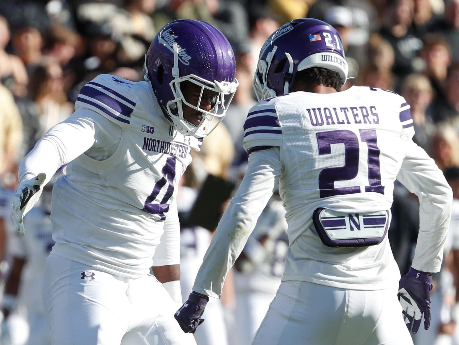 Northwestern Wildcats defensive lineman Anto Saka (4) and Northwestern Wildcats defensive back Damon Walters (21) celebrate after a defensive stop Saturday, Nov. 2, 2024, during the NCAA football game against the Purdue Boilermakers at Ross-Ade Stadium in West Lafayette, Ind. Northwestern Wildcats won 26-20.