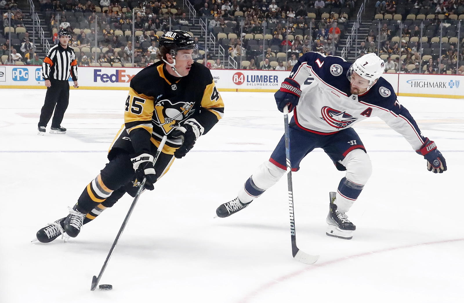 Oct 4, 2024; Pittsburgh, Pennsylvania, USA; Pittsburgh Penguins defenseman Harrison Brunicke (45) skates in on goal against Columbus Blue Jackets center Sean Kuraly (7) during the first period at PPG Paints Arena. (Charles LeClaire-Imagn Images)