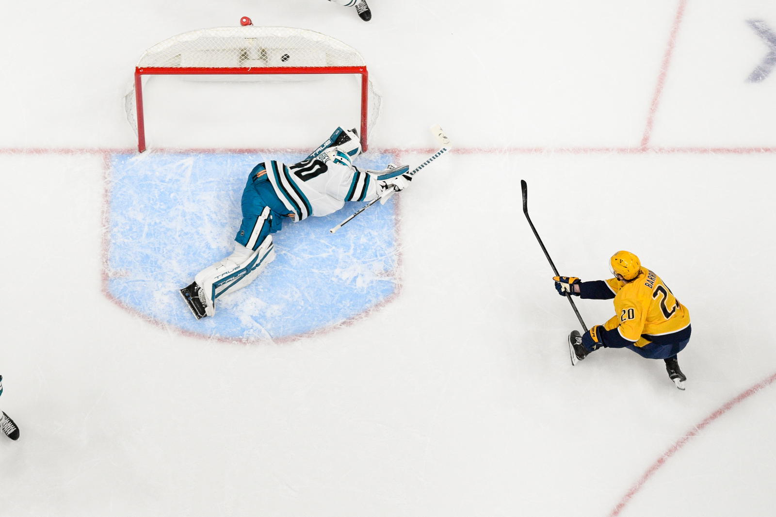 Jan 21, 2025; Nashville, Tennessee, USA; Nashville Predators defenseman Justin Barron (20) scores past San Jose Sharks goaltender Alexandar Georgiev (40) during the second period at Bridgestone Arena. Mandatory Credit: Steve Roberts-Imagn Images