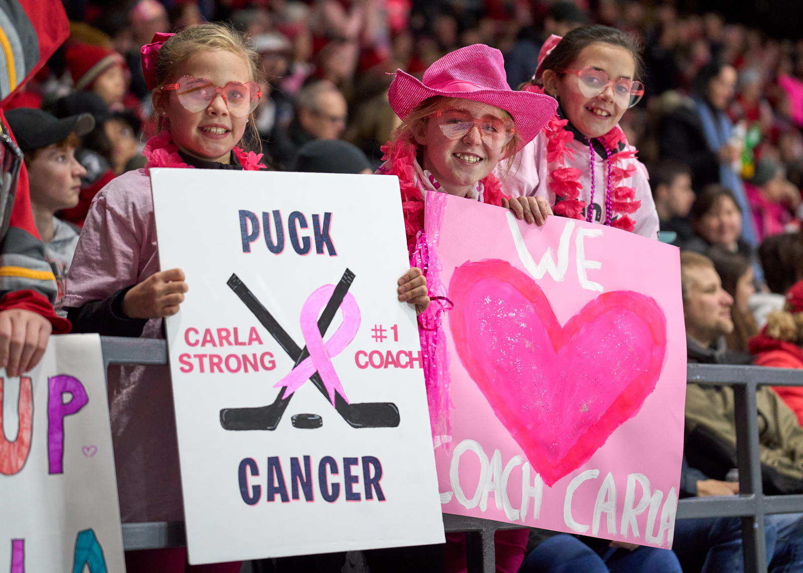 Two Ottawa fans hold signs supporting Carla MacLeod - Photo @ Ellen Bond