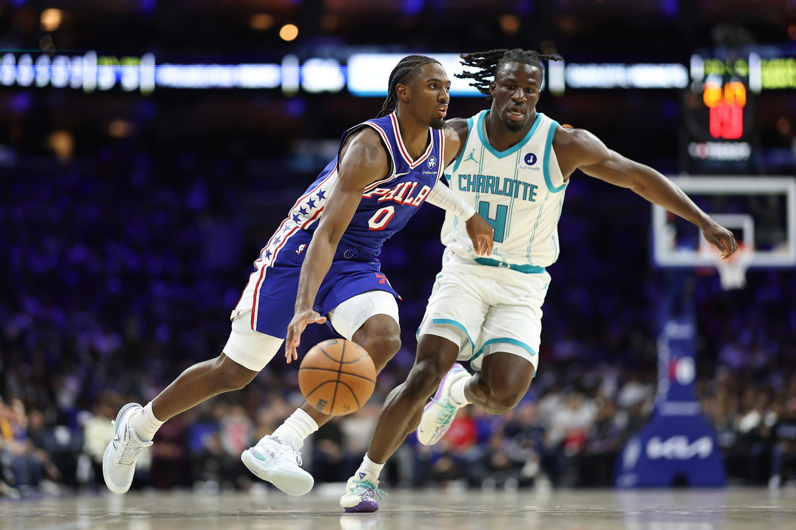 Oct 25, 2025; Philadelphia, Pennsylvania, USA; Philadelphia 76ers guard Tyrese Maxey (0) dribbles the ball past Charlotte Hornets guard Sion James (4) during the second quarter at Xfinity Mobile Arena. Mandatory Credit: Bill Streicher-Imagn Images