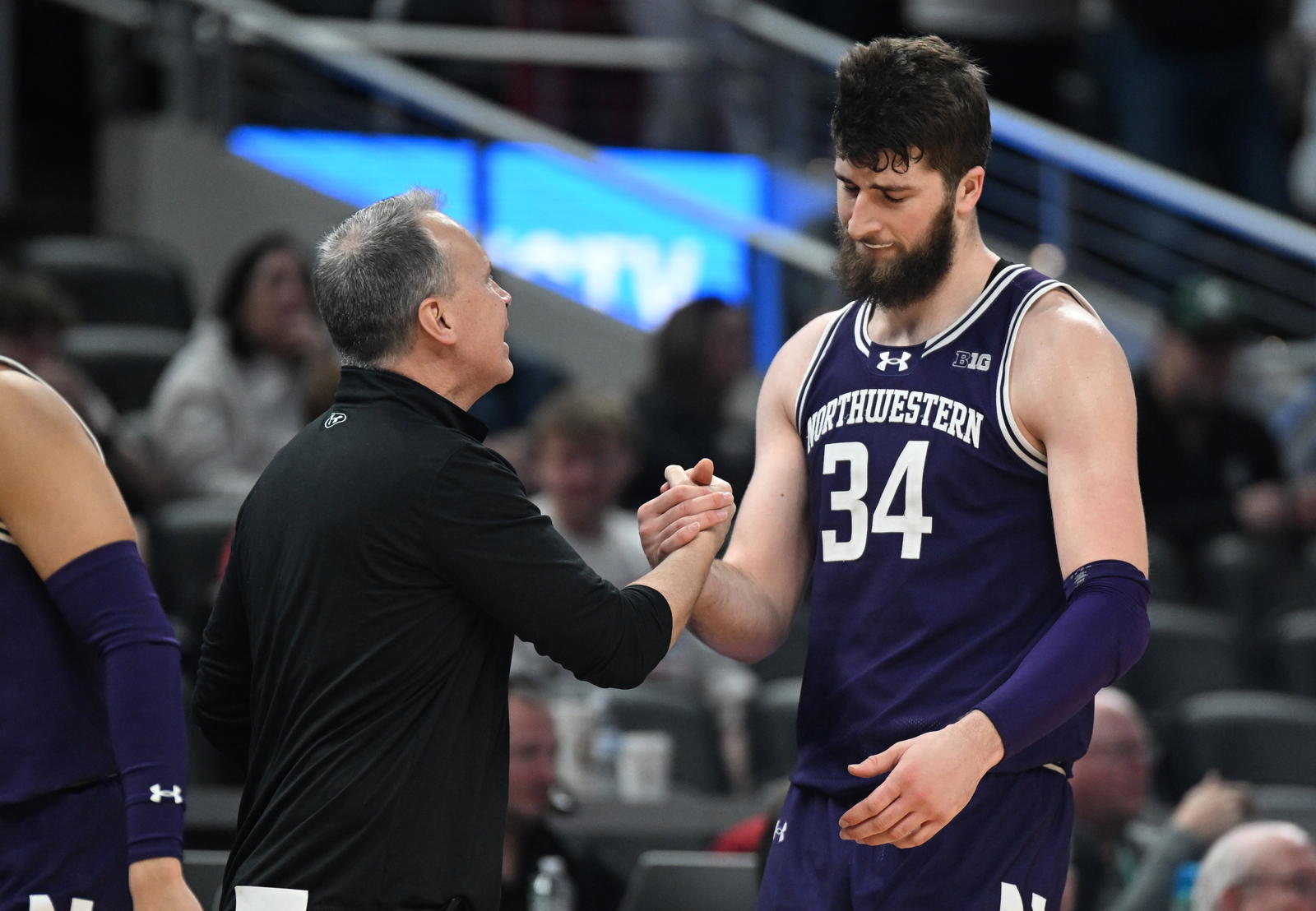 Mar 13, 2025; Indianapolis, IN, USA; Northwestern Wildcats head coach Chris Collins greets Northwestern Wildcats center Matthew Nicholson (34) as he checks out of the game during the second half against the Wisconsin Badgers at Gainbridge Fieldhouse. Mandatory Credit: Robert Goddin-Imagn Images