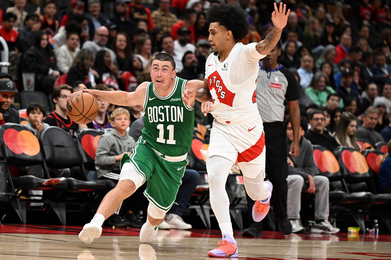 Oct 10, 2025; Toronto, Ontario, CAN; Boston Celtics guard Payton Pritchard (11) dribbles the ball past Toronto Raptors guard Chucky Hepburn (24) in the first half at Scotiabank Arena. (Dan Hamilton/Imagn Images)