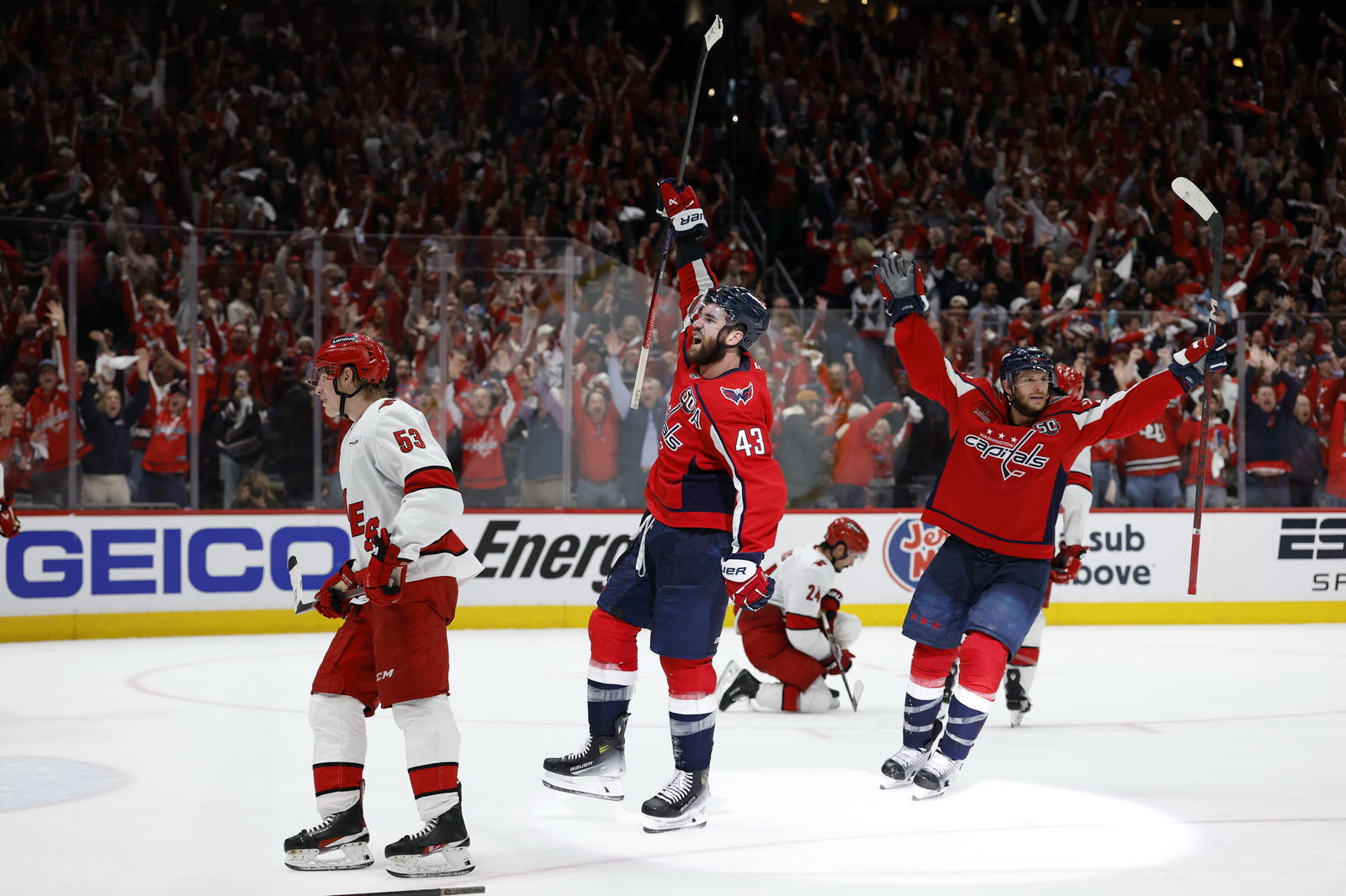 May 8, 2025; Washington, District of Columbia, USA; Washington Capitals right wing Tom Wilson (43) celebrates with Capitals center Nic Dowd (26) after scoring an empty net goal as Carolina Hurricanes right wing Jackson Blake (53) looks on in the third period in game two of the second round of the 2025 Stanley Cup Playoffs at Capital One Arena. Mandatory Credit: Geoff Burke-Imagn Images
