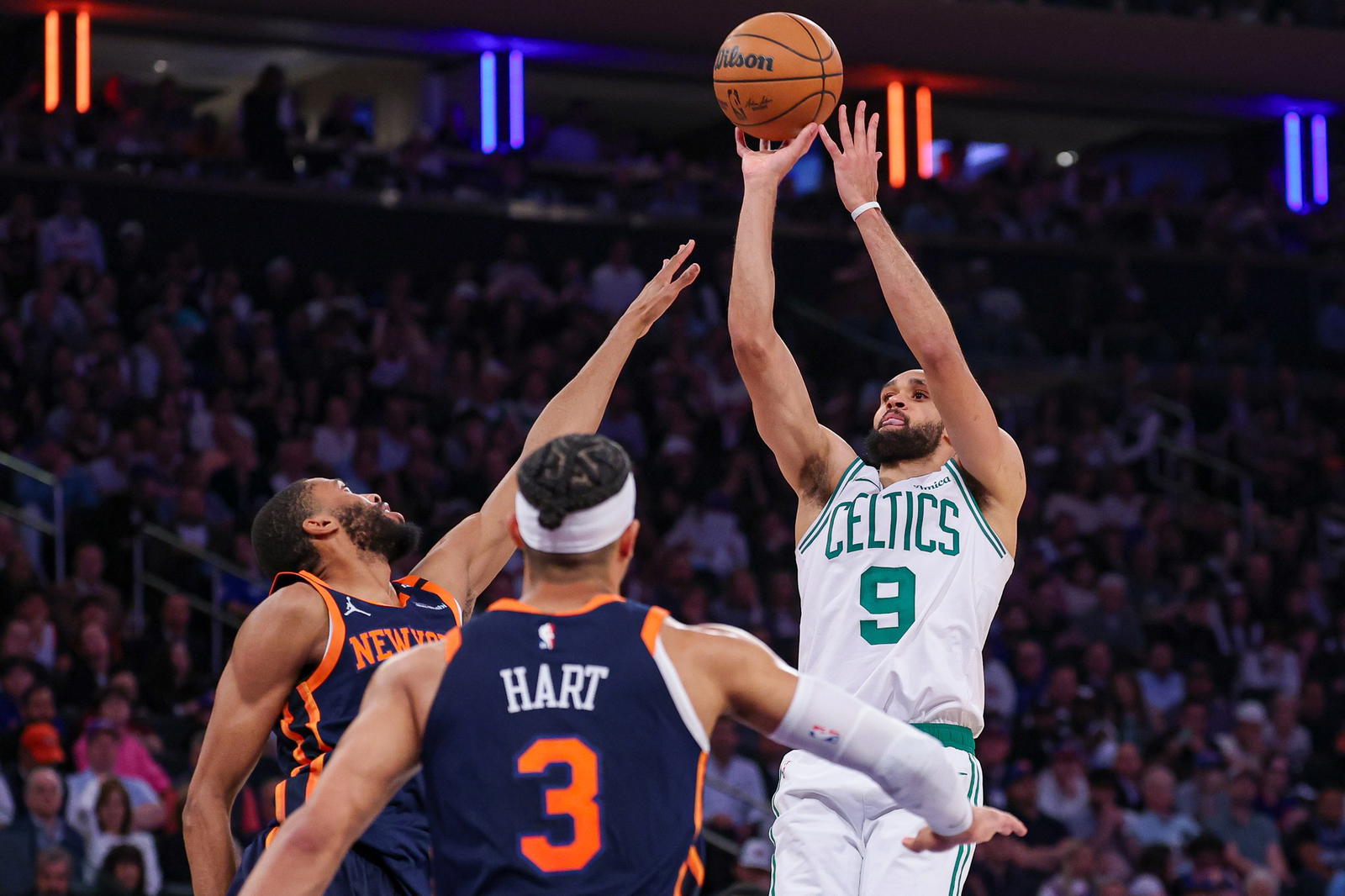 May 12, 2025; New York, New York, USA; Boston Celtics guard Derrick White (9) shoots the ball as New York Knicks guard Josh Hart (3) and forward Mikal Bridges (25) defend in the second half during game four of the second round for the 2025 NBA Playoffs at Madison Square Garden. (Vincent Carchietta/Imagn Images)