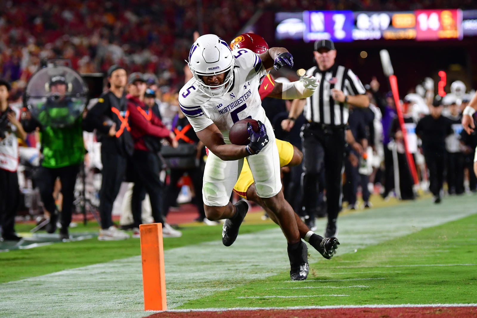 Nov 7, 2025; Los Angeles, California, USA; Northwestern Wildcats running back Caleb Komolafe (5) is stopped short of the goal line by Southern California Trojans safety Kamari Ramsey (7) during the first half at the Los Angeles Memorial Coliseum. Mandatory Credit: Gary A. Vasquez-Imagn Images