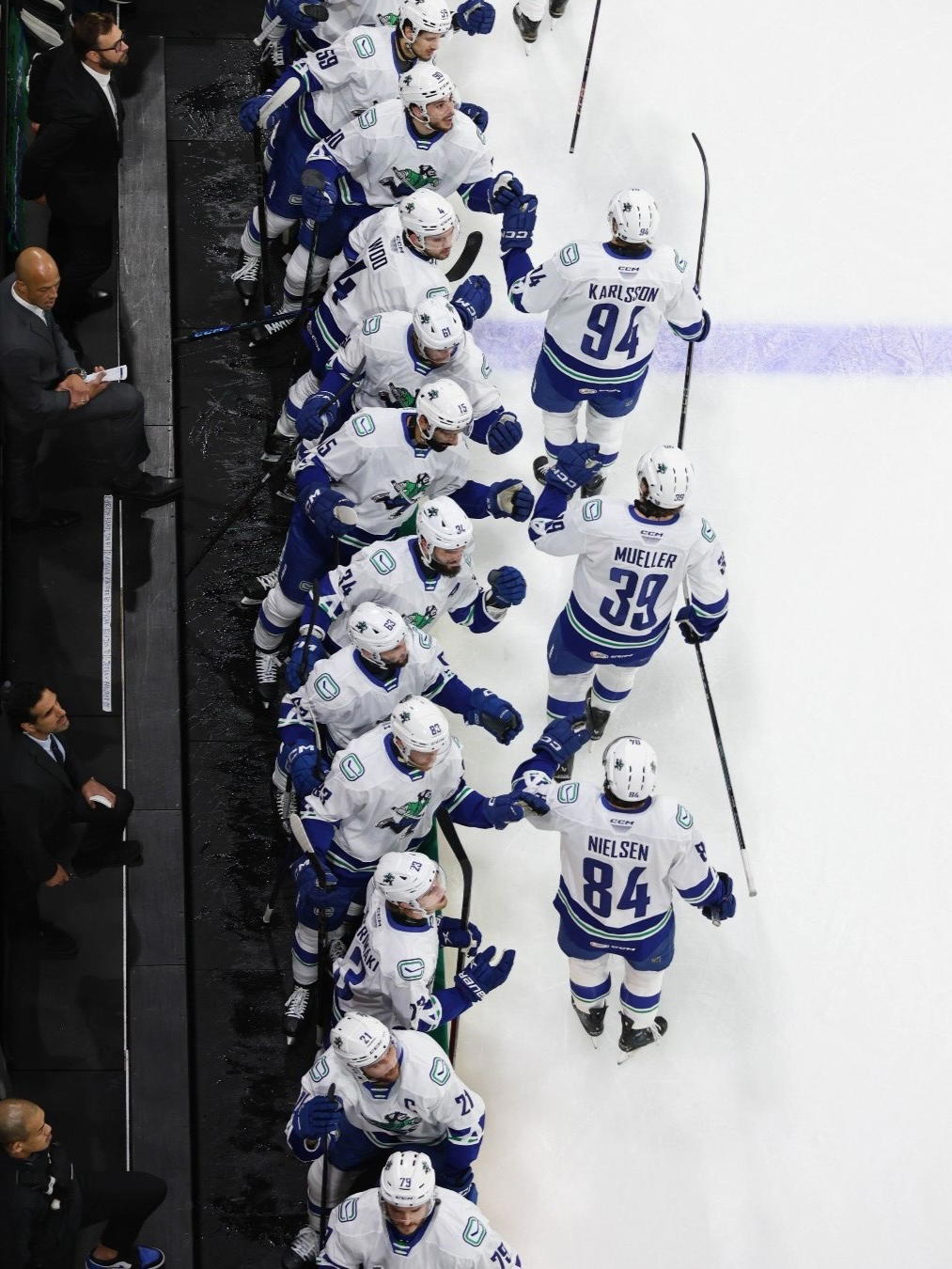 Abbotsford Canucks players Linus Karlsson (94), Ty Mueller (39), and Tristen Nielsen skate by the bench after scoring a goal. (Photo Credit: @AbbyCanucks/X) 