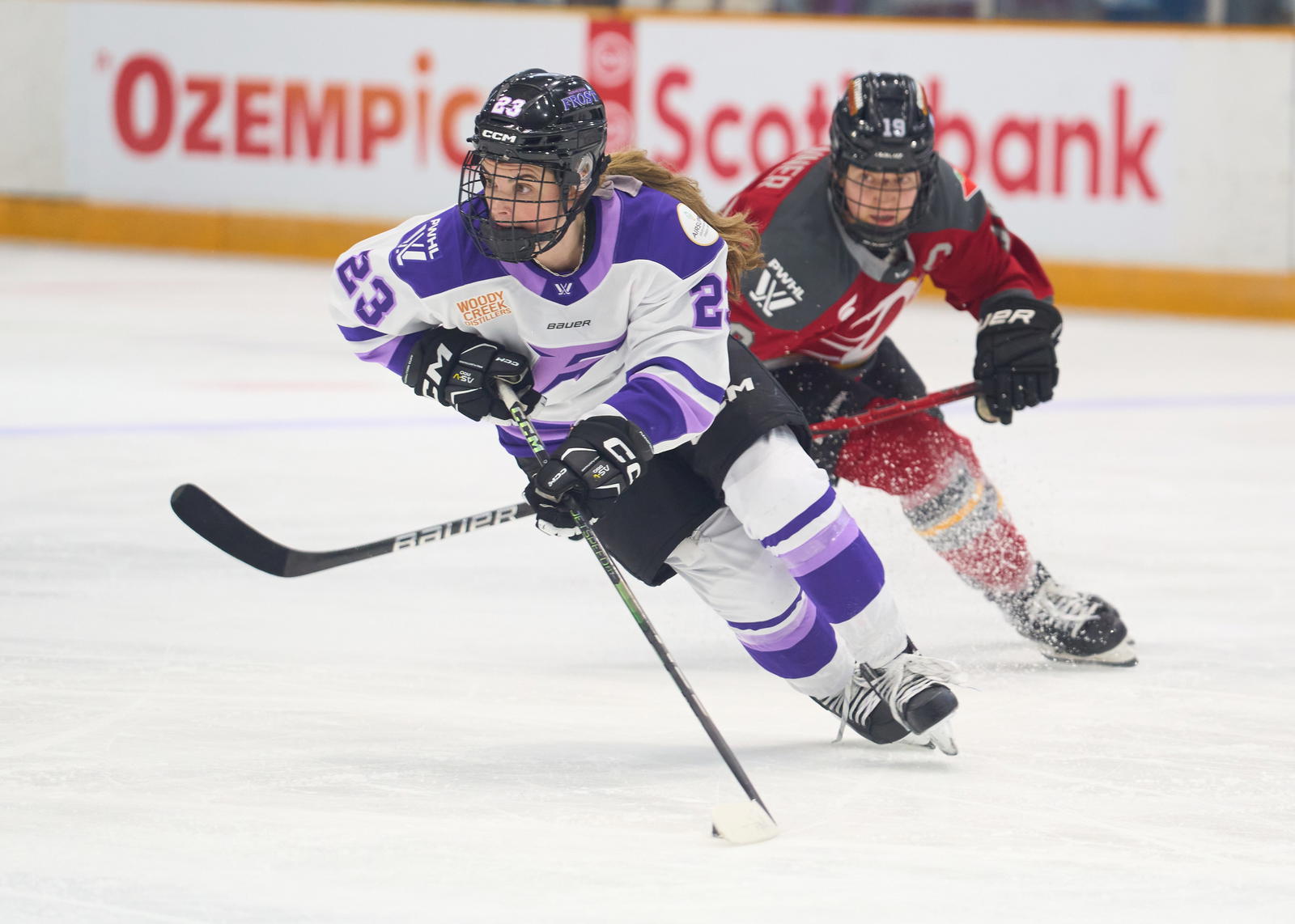 Mellissa Channell-Watkins carries the puck for the Minnesota Frost with Ottawa's Brianne Jenner in pursuit - Photo @ Ellen Bond
