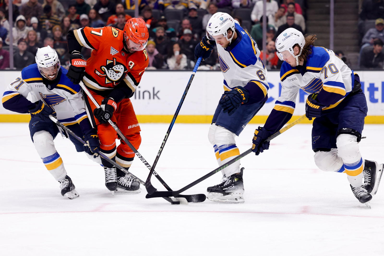 St. Louis Blues skaters Mathieu Joseph (71), Philip Broberg (6) and Oskar Sundqvist (70) pressure Anaheim Ducks forward Alex Killorn for a puck on Friday. (Ryan Sun-Imagn Images)