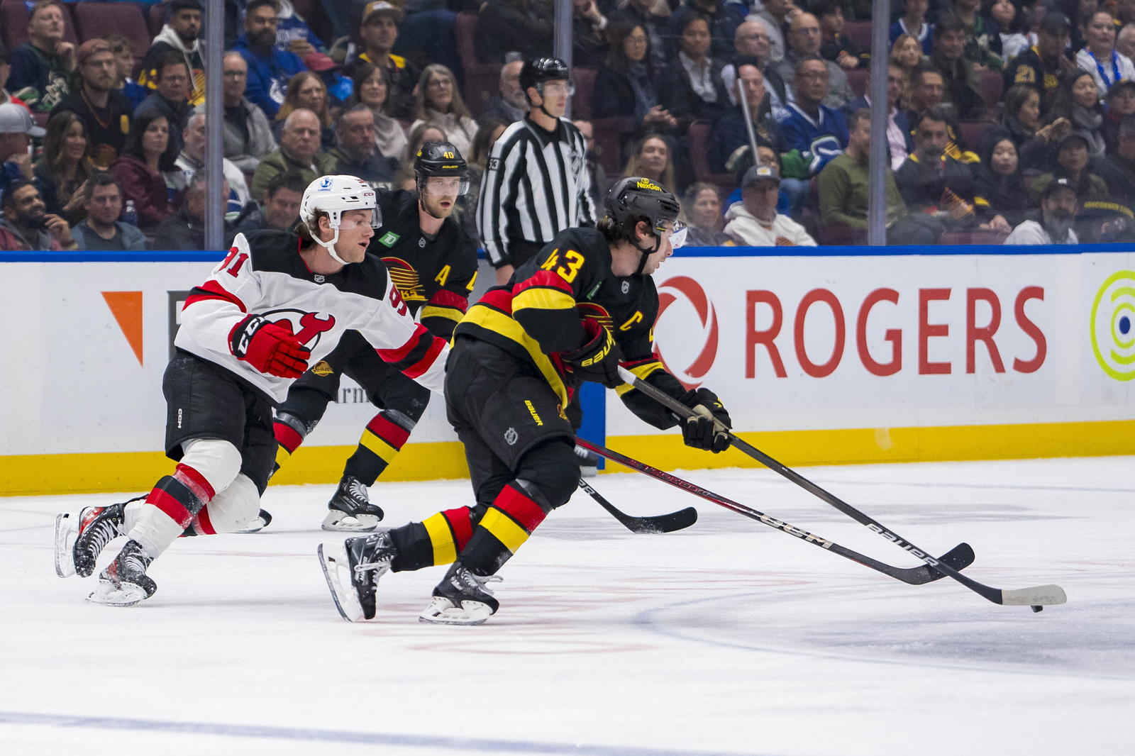 Oct 30, 2024; Vancouver, British Columbia, CAN; New Jersey Devils forward Dawson Mercer (91) stick checks Vancouver Canucks defenseman Quinn Hughes (43) during the first period at Rogers Arena. Mandatory Credit: Bob Frid-Imagn Images