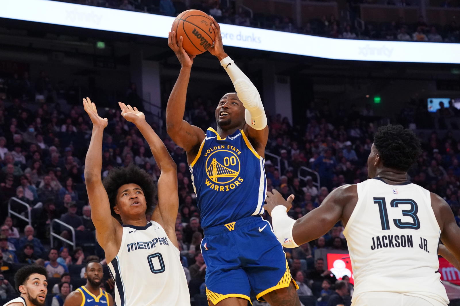 Jan 4, 2025; San Francisco, California, USA; Golden State Warriors forward Jonathan Kuminga (00) shoots a jumpshot against Memphis Grizzlies forward Jaylen Wells (0) and forward/center Jaren Jackson Jr. (13) in the second quarter at Chase Center. Mandatory Credit: David Gonzales-Imagn Images