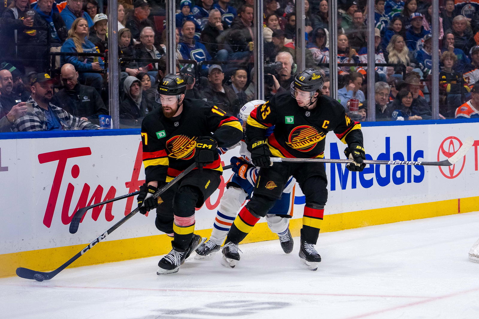Jan 18, 2025; Vancouver, British Columbia, CAN; Vancouver Canucks defenseman Quinn Hughes (43) watches defenseman Filip Hronek (17) handle the puck against the Edmonton Oilers in the third period at Rogers Arena. Mandatory Credit: Bob Frid-Imagn Images