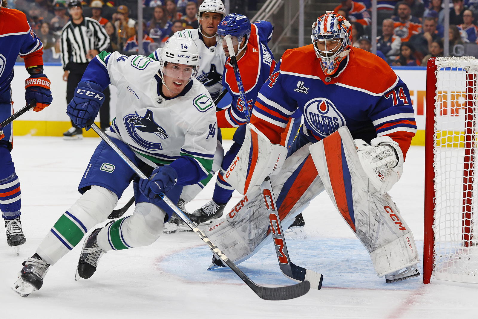 Sep 28, 2025; Edmonton, Alberta, CAN; Vancouver Canucks forward Joseph LaBate (14) looks for a pass in front of Edmonton Oilers goaltender Stuart Skinner (74) during the second period at Rogers Place. Mandatory Credit: Perry Nelson-Imagn Images