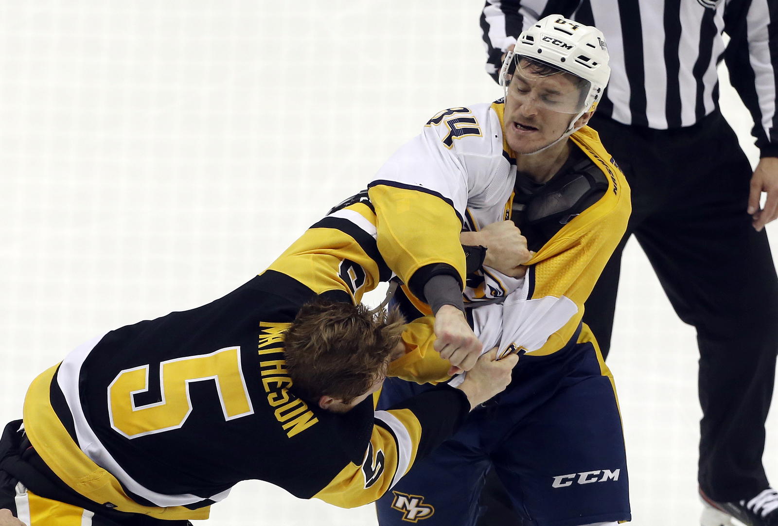 Apr 10, 2022; Pittsburgh, Pennsylvania, USA; Pittsburgh Penguins defenseman Mike Matheson (5) and Nashville Predators left wing Tanner Jeannot (84) fight during the second period at PPG Paints Arena. Mandatory Credit: Charles LeClaire-Imagn Images
