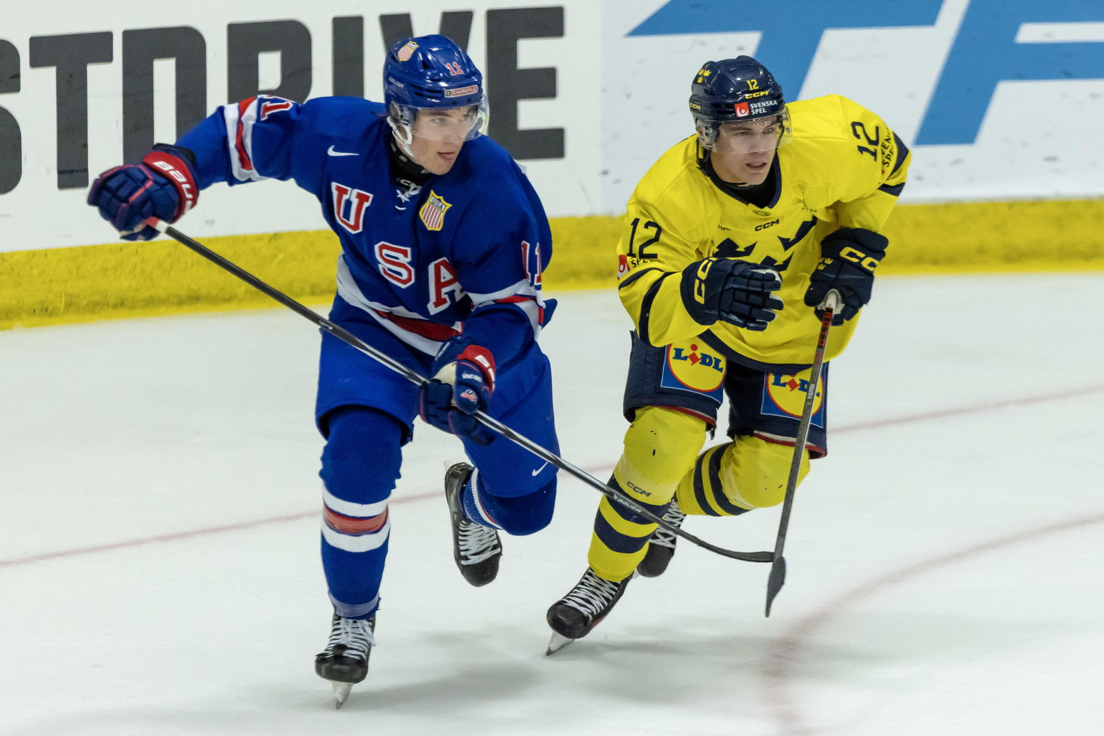 Aug 2, 2024; Plymouth, MI, USA; USA’s forward Colin Ralph (11) battles for position with Sweden's forward Melvin Fernstrom (12) during the second period of the 2024 World Junior Summer Showcase at USA Hockey Arena. Mandatory Credit: David Reginek-Imagn Images