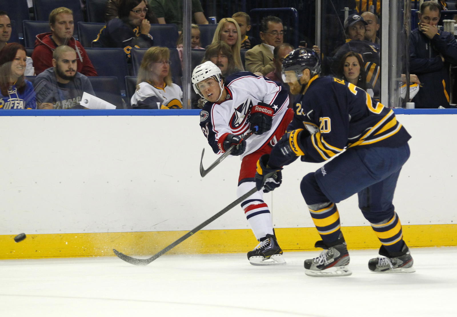 Sep 25, 2013; Buffalo, NY, USA; Columbus Blue Jackets center Jonathan Audy-Marchessault (36) takes a shot on goal while being defended by Buffalo Sabres defenseman Henrik Tallinder (20) during the first period at First Niagara Center. Mandatory Credit: Timothy T. Ludwig-Imagn Images