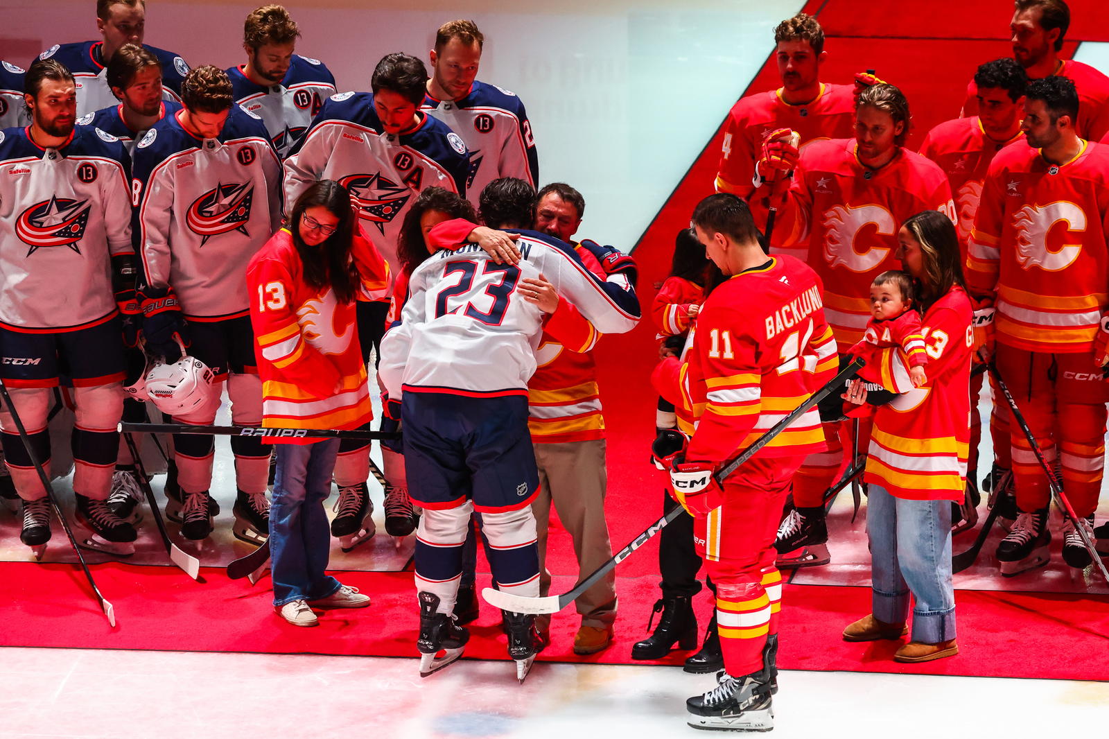 Dec 3, 2024; Calgary, Alberta, CAN; Johnny Gaudreau’s family during ceremonial puck drop by Columbus Blue Jackets center Sean Monahan (23) and Calgary Flames center Mikael Backlund (11) during the first period at Scotiabank Saddledome. Photo Credit: Sergei Belski-Imagn Images