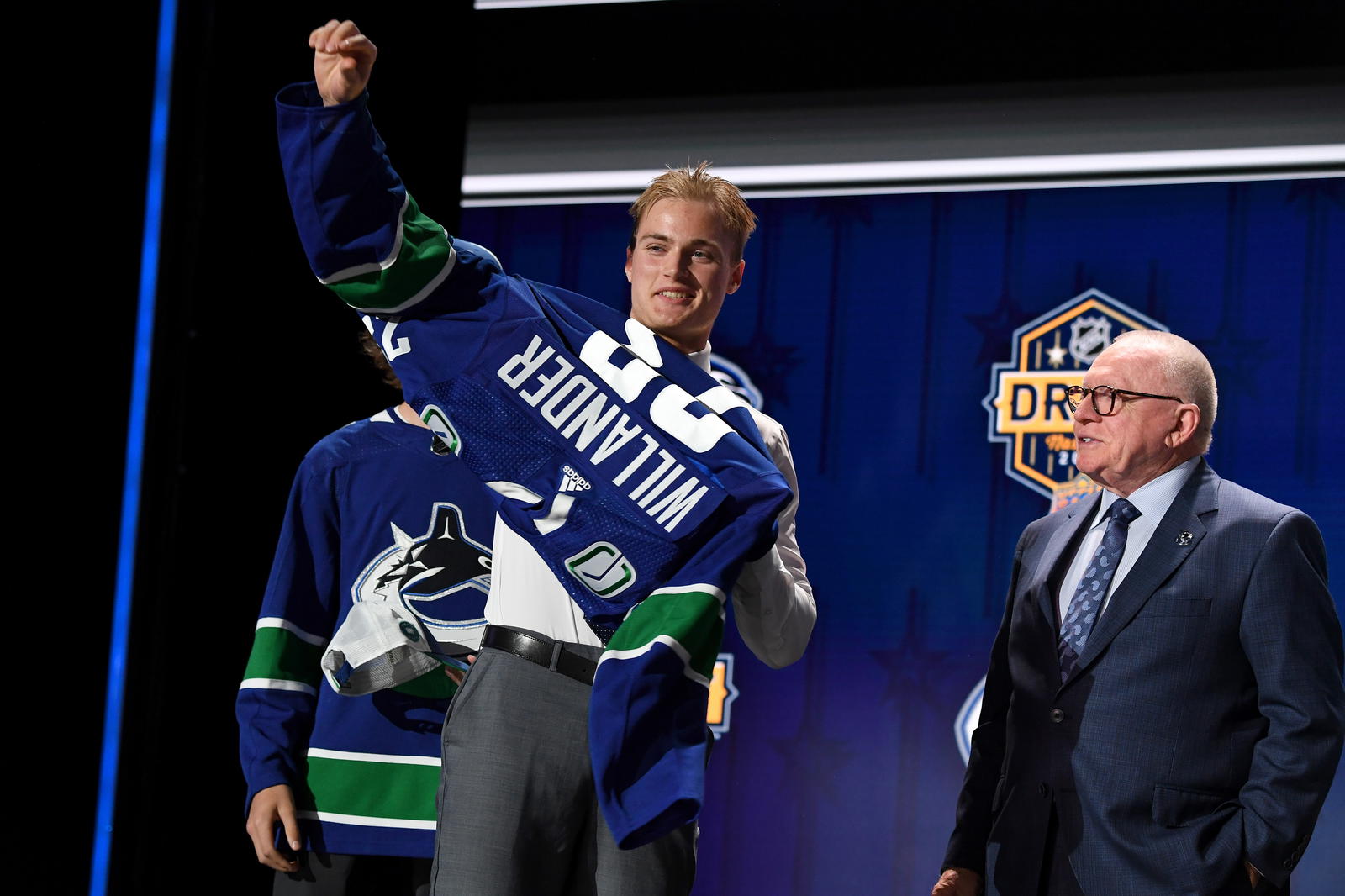 Jun 28, 2023; Nashville, Tennessee, USA; Vancouver Canucks draft pick Tom Willander puts on his sweater after being selected with the eleventh pick in round one of the 2023 NHL Draft at Bridgestone Arena. Mandatory Credit: Christopher Hanewinckel-Imagn Images