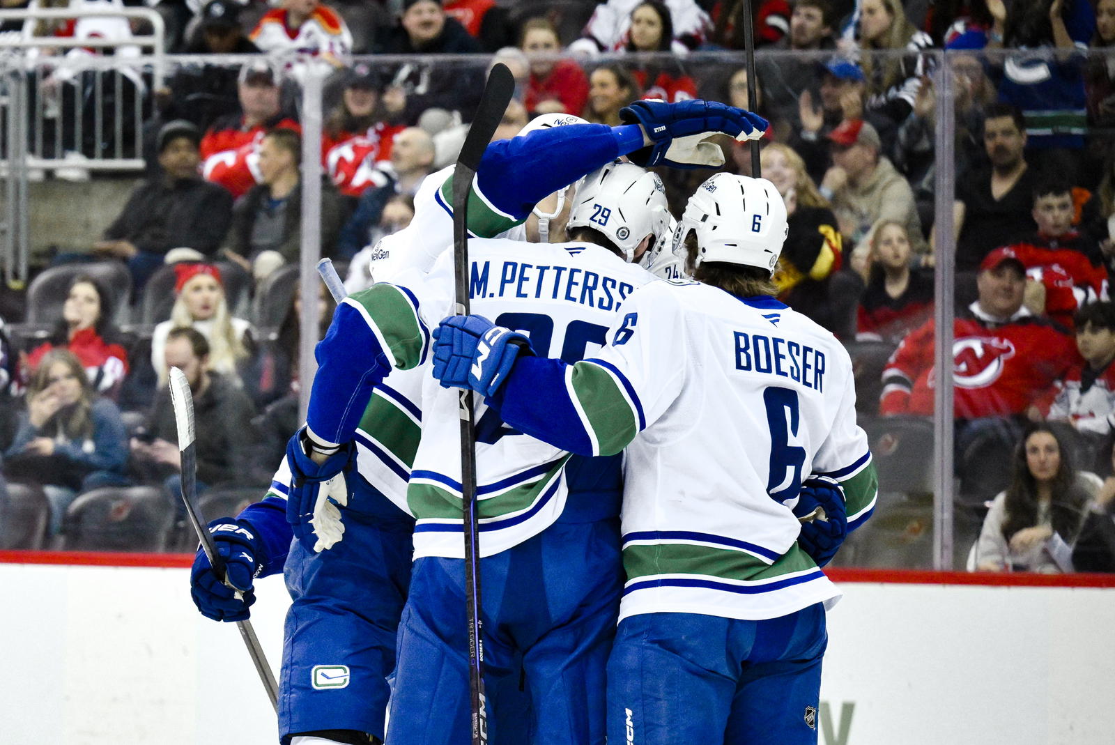 Mar 24, 2025; Newark, New Jersey, USA; Vancouver Canucks center Pius Suter (24) celebrates with teammates after scoring a goal against the New Jersey Devils during the first period at Prudential Center. Mandatory Credit: John Jones-Imagn Images