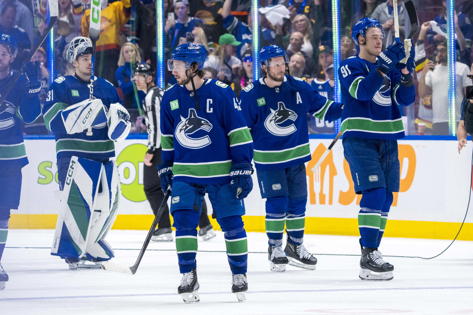 May 20, 2024; Vancouver, British Columbia, CAN; Vancouver Canucks defenseman Quinn Hughes (43) and forward J.T. Miller (9) and defenseman Nikita Zadorov (91) and goalie Arturs Silvos (31) wave to the crowd after the Edmonton Oilers win in game seven of the second round of the 2024 Stanley Cup Playoffs at Rogers Arena. Mandatory Credit: Bob Frid-Imagn Images
